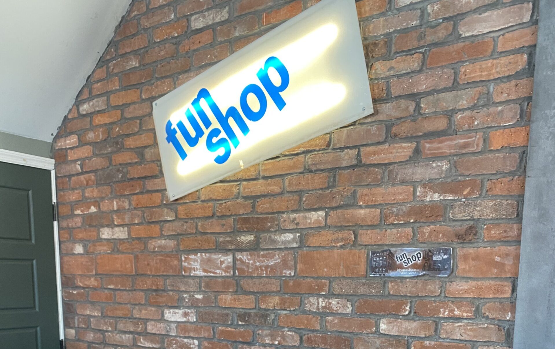 fun shop sign on brick wall